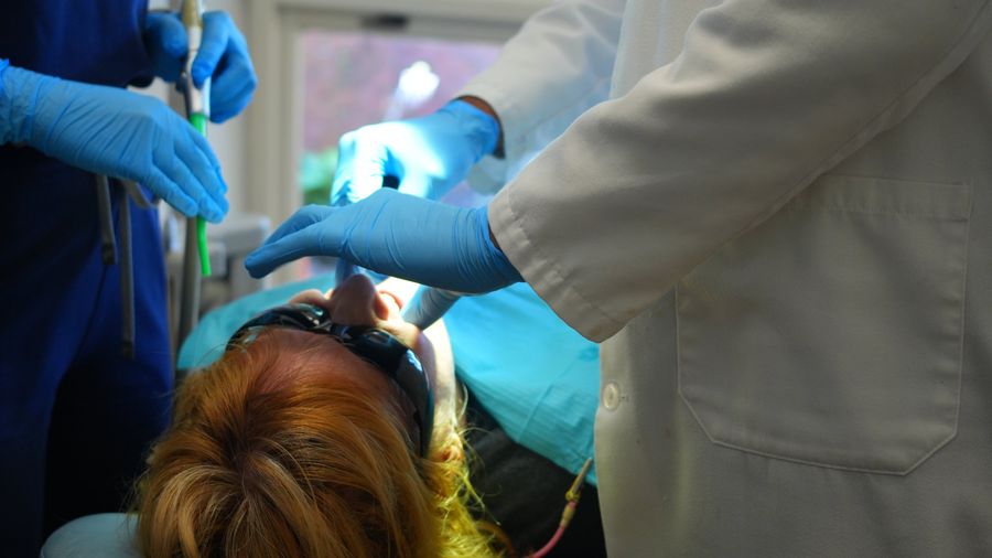A patient in the dental chair wearing protective glasses during treatment